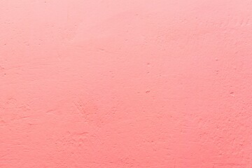 Old pink wall in spots, cracks, stains. Painted concrete wall in abstract grunge style loft. Vintage wall background texture for backgrounds, portraits, posters.