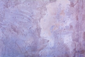 Old purple wall in spots, cracks, stains. Painted concrete wall in abstract grunge style loft. Vintage wall background texture for backgrounds, portraits, posters.