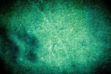 Old green wall in spots, cracks, stains. Painted concrete wall in abstract grunge style loft. Vintage wall background texture for backgrounds, portraits, posters.