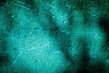 Old green wall in spots, cracks, stains. Painted concrete wall in abstract grunge style loft. Vintage wall background texture for backgrounds, portraits, posters.