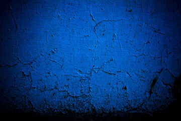 Old blue wall in spots, cracks, stains. Painted concrete wall in abstract grunge style loft. Vintage wall background texture for backgrounds, portraits, posters.