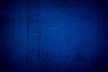 Old blue wall in spots, cracks, stains. Painted concrete wall in abstract grunge style loft. Vintage wall background texture for backgrounds, portraits, posters.