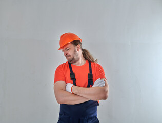 repairman on a white wall background stands