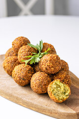 A traditional Israeli dish fresh falafel on a wooden board, garnished with a sprig of parsley. Middle Eastern cuisine. Vegetarian bean meal