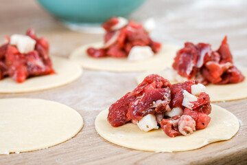 A man is holding a khinkali in close-up. Cook in the kitchen. The process of preparing a national dish.