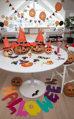 lot of pumpkins with painted faces on a table in a bright apartment