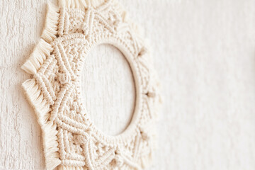 Fototapeta na wymiar Macrame mandala. Macrame wreathe on a white background close up. Natural cotton thread. Eco home decor. Copy space