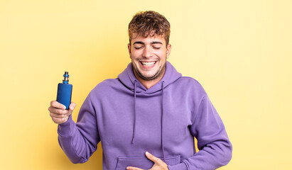 young handsome man laughing out loud at some hilarious joke. vaporizer concept