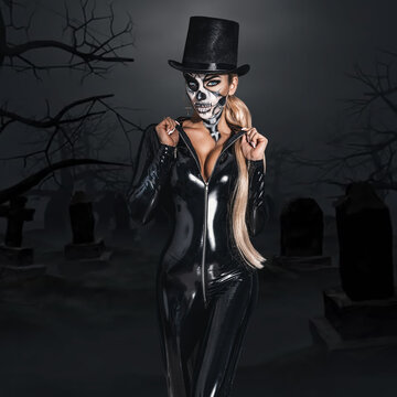 Female model in Halloween. Sexy woman in top hat and skull make up. Halloween costume concept.