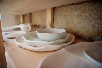 Handmade ceramic kitchen items on wooden shelves