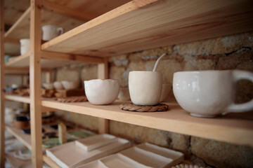 Fototapeta na wymiar Handmade ceramic kitchen items on wooden shelves