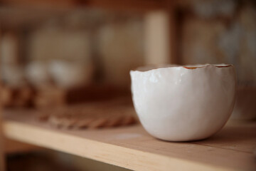 Handmade ceramic kitchen items on wooden shelves