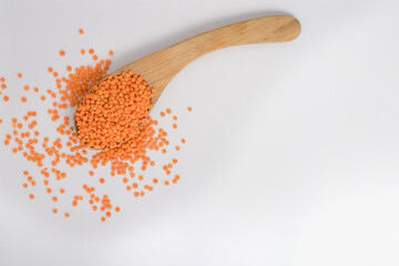 Red Lentils on a wooden spoon isolated on white background