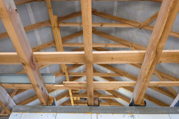 Wooden roof structures of a new residential building. Unfinished brick building under development