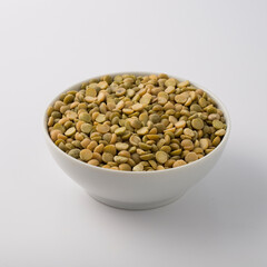 Green lentils on white round pot isolated