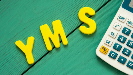 YMS - acronym is lined with letters of the alphabet on a wooden green background
