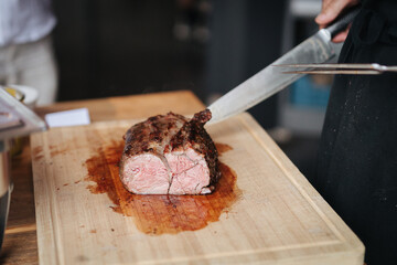 Cook cutting meat at a barbecue