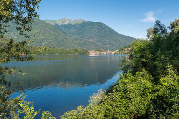 Fototapeta na wymiar Beautiful Italian bathing lake with clear waters. Lake Mergozzo with in the background the town of Mergozzo, valle Ossola. Province of Verbano Cusio Ossola in Piedmont region, Italy