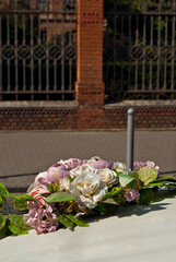 White wedding flowers attached to a gray car. Wedding floristics and decorations close up. Wedding and holiday concept.