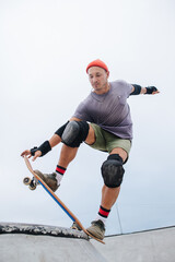Confident mature skater in a watch cap starting his roll © zzzdim