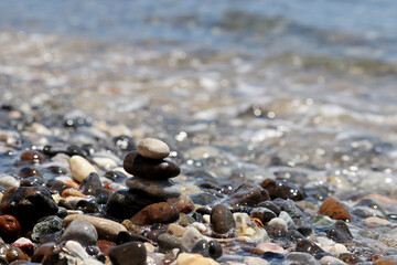 Wet pebble stones on blurred background of sea waves. Beach vacation concept