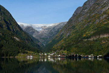 Fototapeta premium Efecto espejo en el fiordo con las montañas noruegas en el fondo