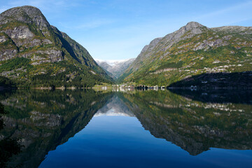 Fototapeta na wymiar Efecto espejo en el fiordo con las montañas noruegas en el fondo
