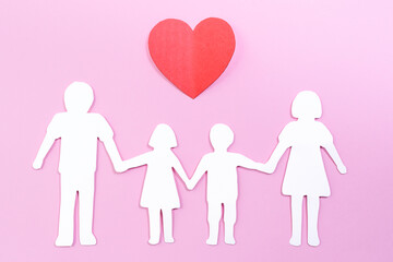 Paper family cut out on bright pink background with paper heart. Family home, foster care, family mental health, divorce and family crisis concept