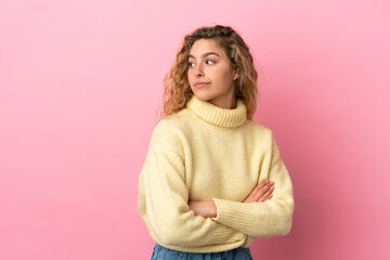 Fototapeta premium Young blonde woman isolated on pink background keeping the arms crossed