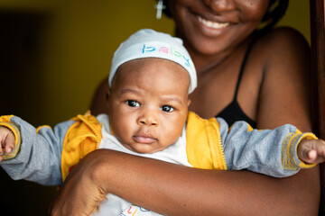 African American young mother holding her baby indoors