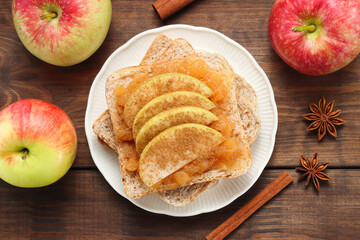 Naklejka na ściany i meble Sandwich with jam and sliced apples sprinkled with cinnamon at the dark wooden background with anise and apples
