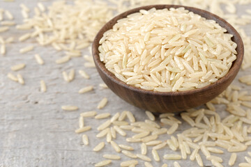 closeup of uncooked long brown rice on the wooden table