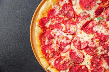 Pizza salami or pepperoni sausage, cheese, tomato sauce, dough fresh portion ready to eat meal snack on the table copy space food background rustic. top view