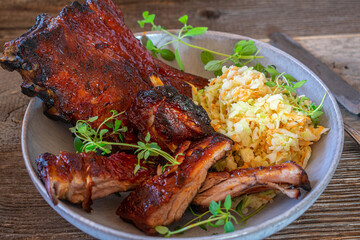 Spareribs with salad on wooden table