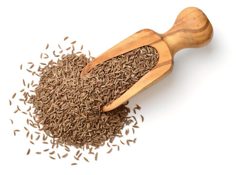 dried caraway seeds in the wooden spoon, isolated on white, top view