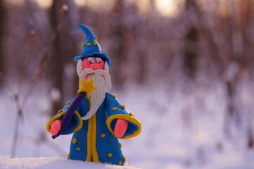 Figure of a wizard in the winter forest. A fairy-tale character.