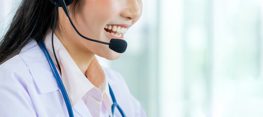 Banner and selective focus on smiling of Asian doctor with headsets, making online telemedicine,...
