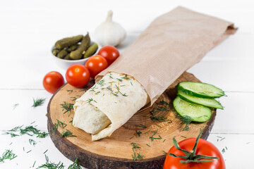 Shawarma sandwich gyro fresh roll of lavash (pita bread) chicken beef shawarma falafel RecipeTin Eatsfilled with grilled meat, mushrooms, cheese. Traditional Middle Eastern snack. On wooden background