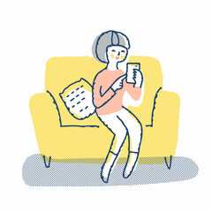 ソファーに座ってスマホを見ている若い女性
