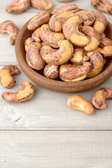 roasted cashew nuts in the wooden bowl on the table