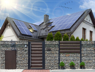 Solar panels on a gable roof. Beautiful, large modern house and solar energy. Rays of the sun.