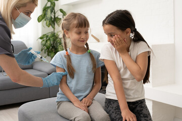 nurse giving vaccination injection to little girl patient