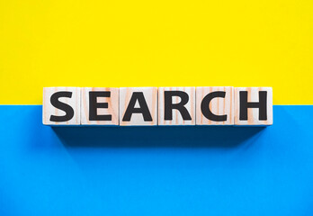 Word SEARCH on wooden cubes with word on beautiful yellow and blue background. Business, media marketing concept.