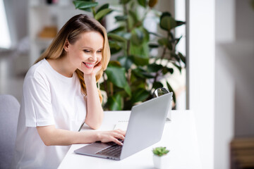 Fototapeta premium Photo portrait woman blonde hair wearing white clothes working from home on computer