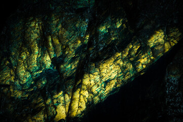 Detail of colorful yellow cyan labradorite semi-precious gemstone. Macro close-up of the texture.  