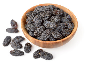 black raisins in the wooden bowl, isolated on white background