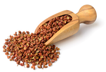 dried Szechuan peppercorns in the wooden scoop, isolated on the white background