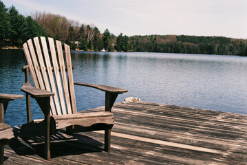 Wooden chair on the pier near the lake on a sunny morning