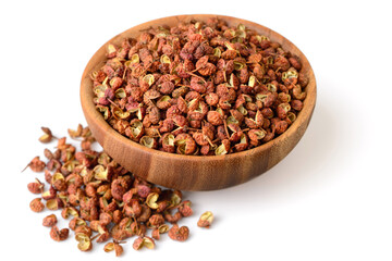 dried Szechuan peppercorns in the wooden bowl, isolated on the white background