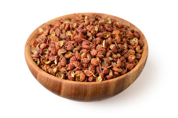 dried Szechuan peppercorns in the wooden bowl, isolated on the white background